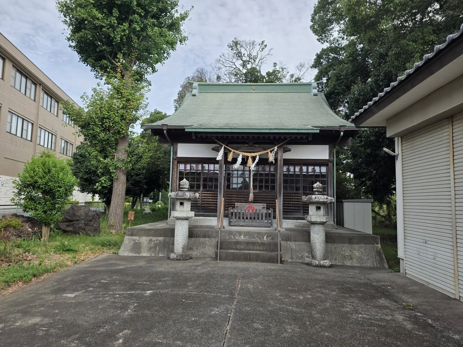 参道の正面に建つ社殿。緑青色の屋根と一対の石灯籠。平成10年（1998）に建て替えられた現社殿。