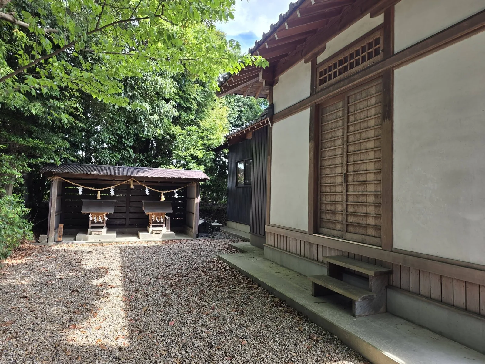 屋根付きの覆屋の中に並ぶ二つの境内社。注連縄が掛けられている。