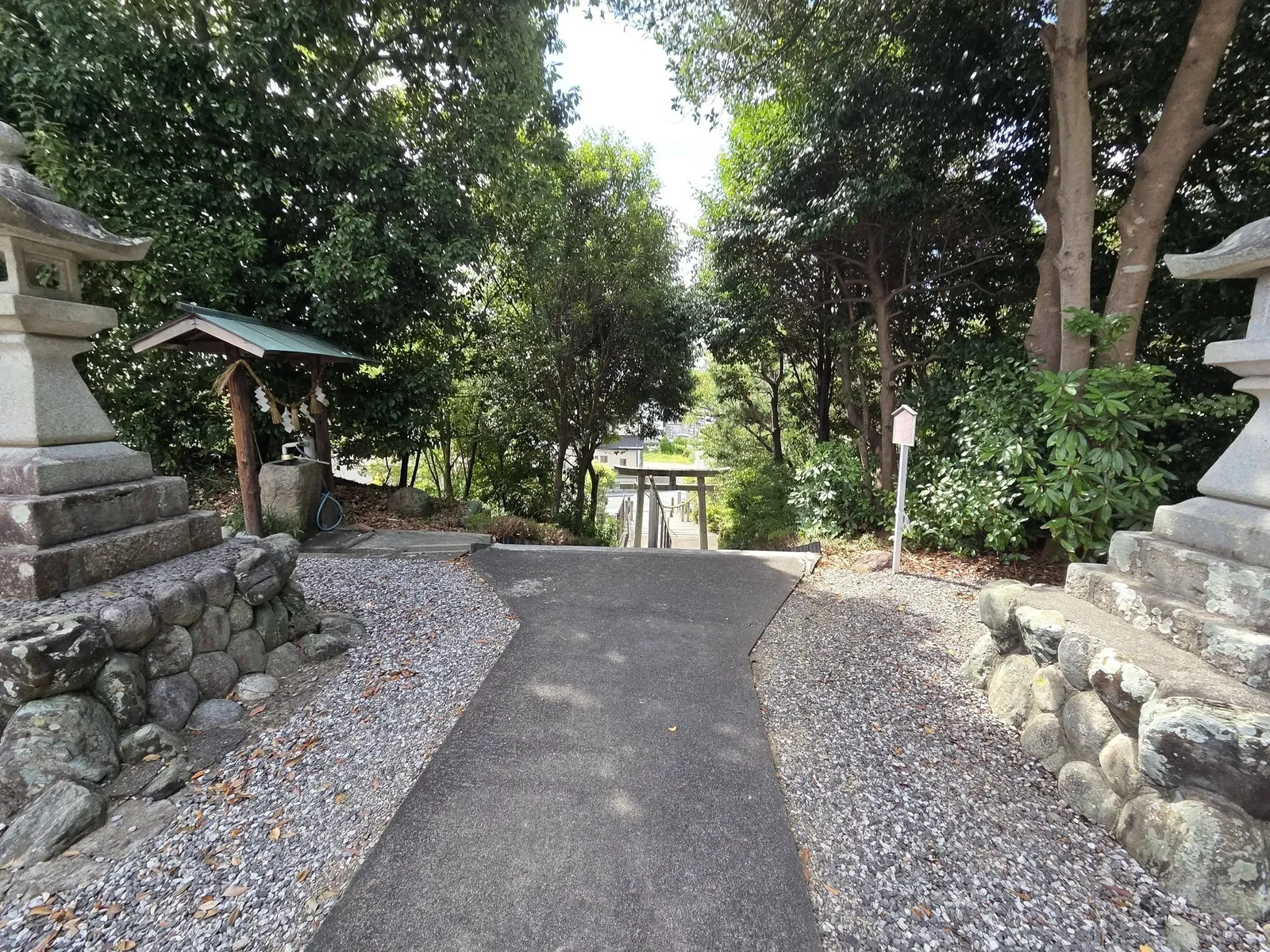 石灯籠の脇から見下ろす参道。石段の先に鳥居が見える。