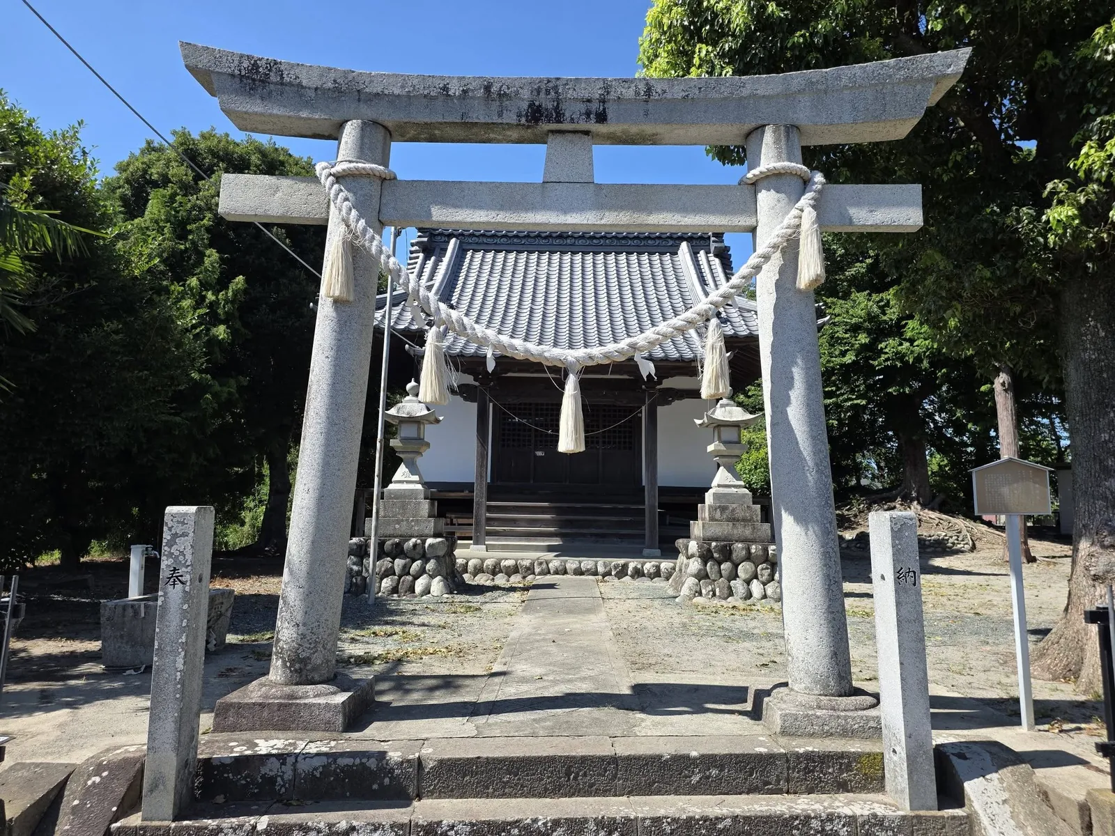 注連縄を掛けた石造鳥居から社殿を望む。