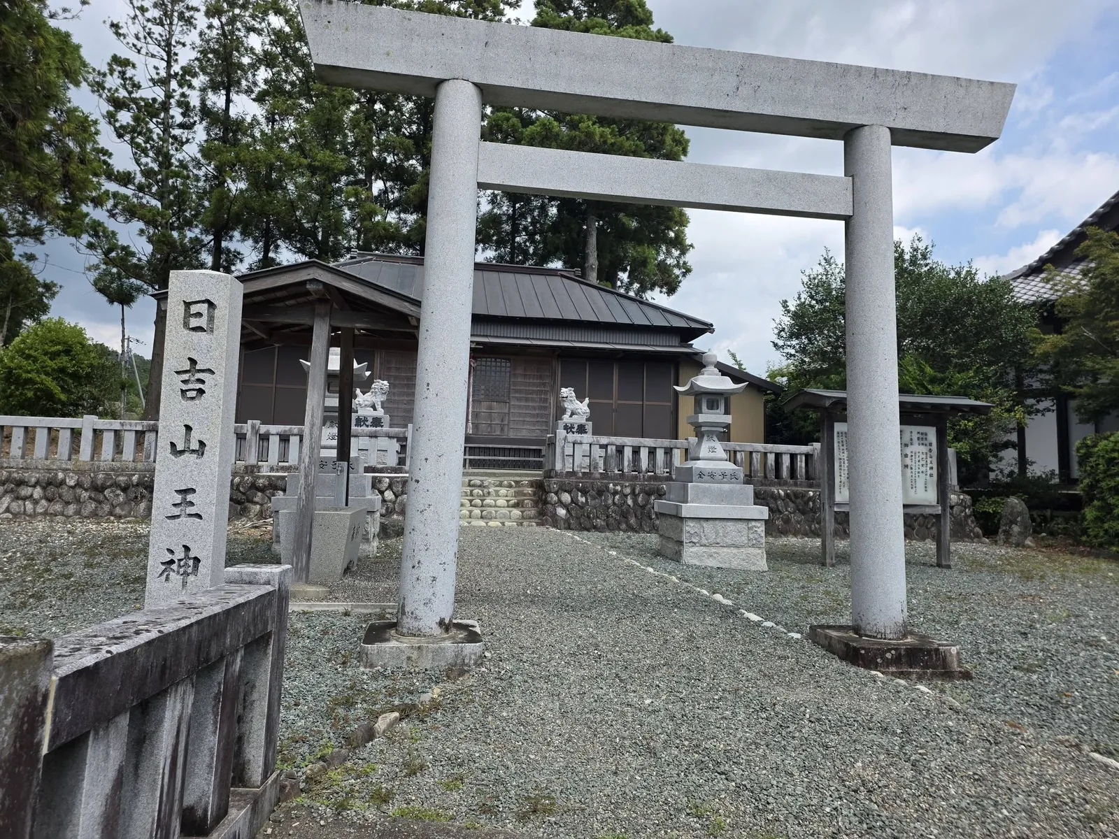 「日吉山王神」と刻む社号標と石造鳥居。