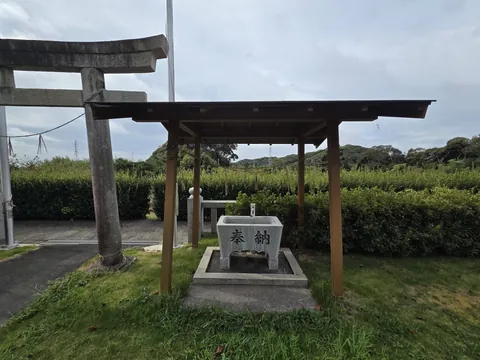 鳥居脇の手水舎。石造手水鉢の正面に「奉納」と刻む。