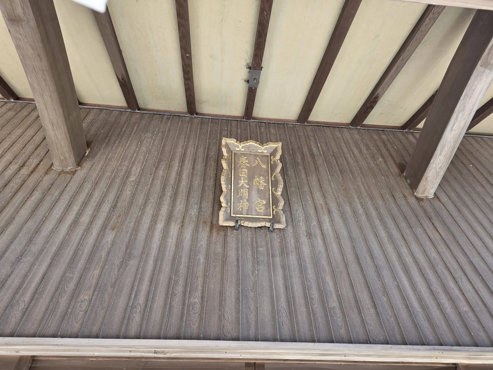 拝殿軒下に掲げられた扁額。「八幡宮」「春日大明神」の文字が読める。