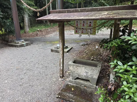 境内の手水舎と石造手水鉢。背後に掲示板を設ける。