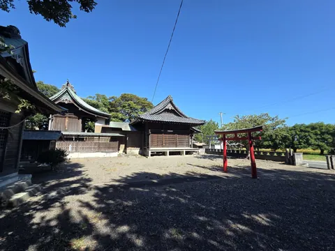 側方から見た駒場神社の社殿と朱塗りの鳥居。