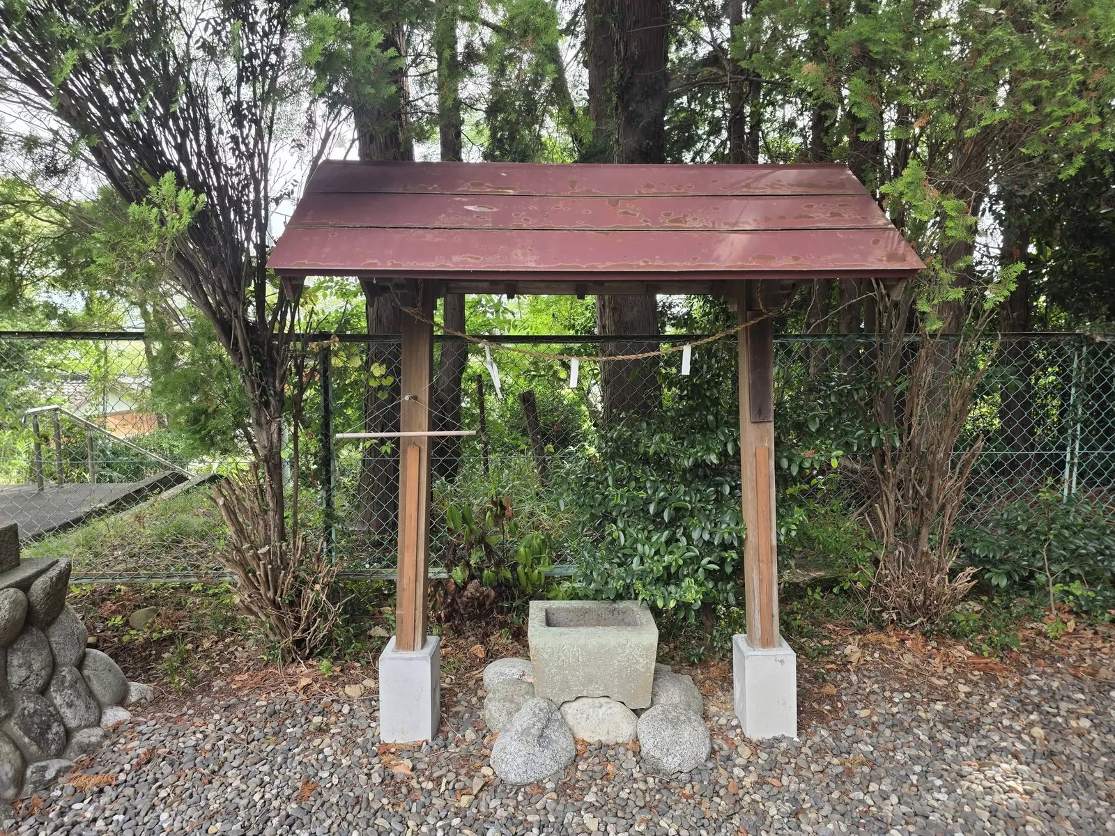 境内の手水舎。簡素な木造屋根の下に石造手水鉢を据える。