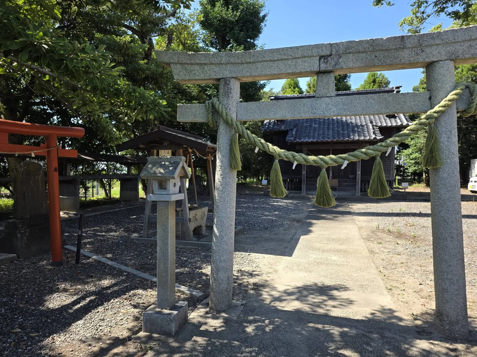 注連縄を掛けた石造鳥居から社殿を望む。