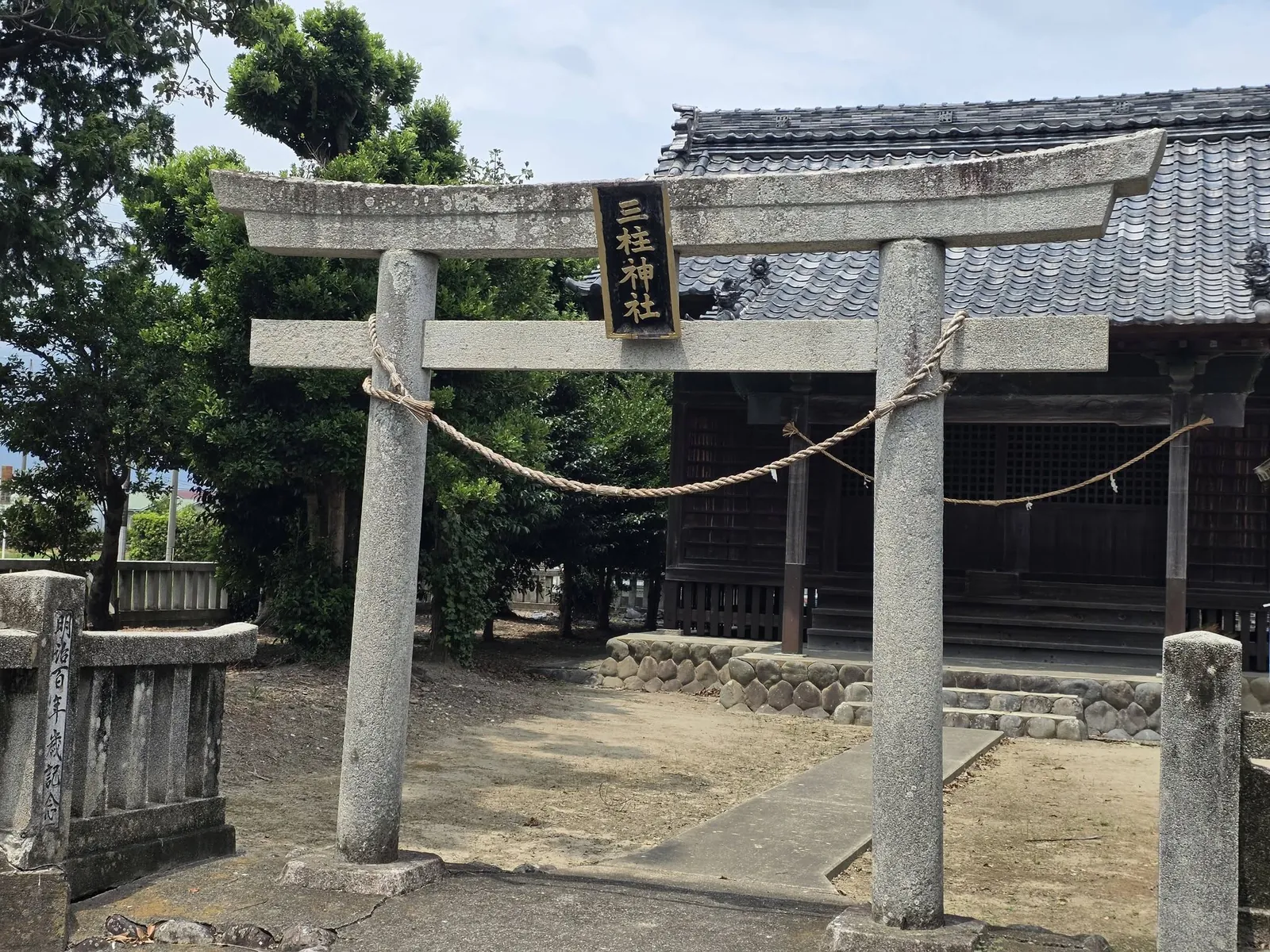 「三柱神社」の神額を掲げた石造鳥居と社殿。