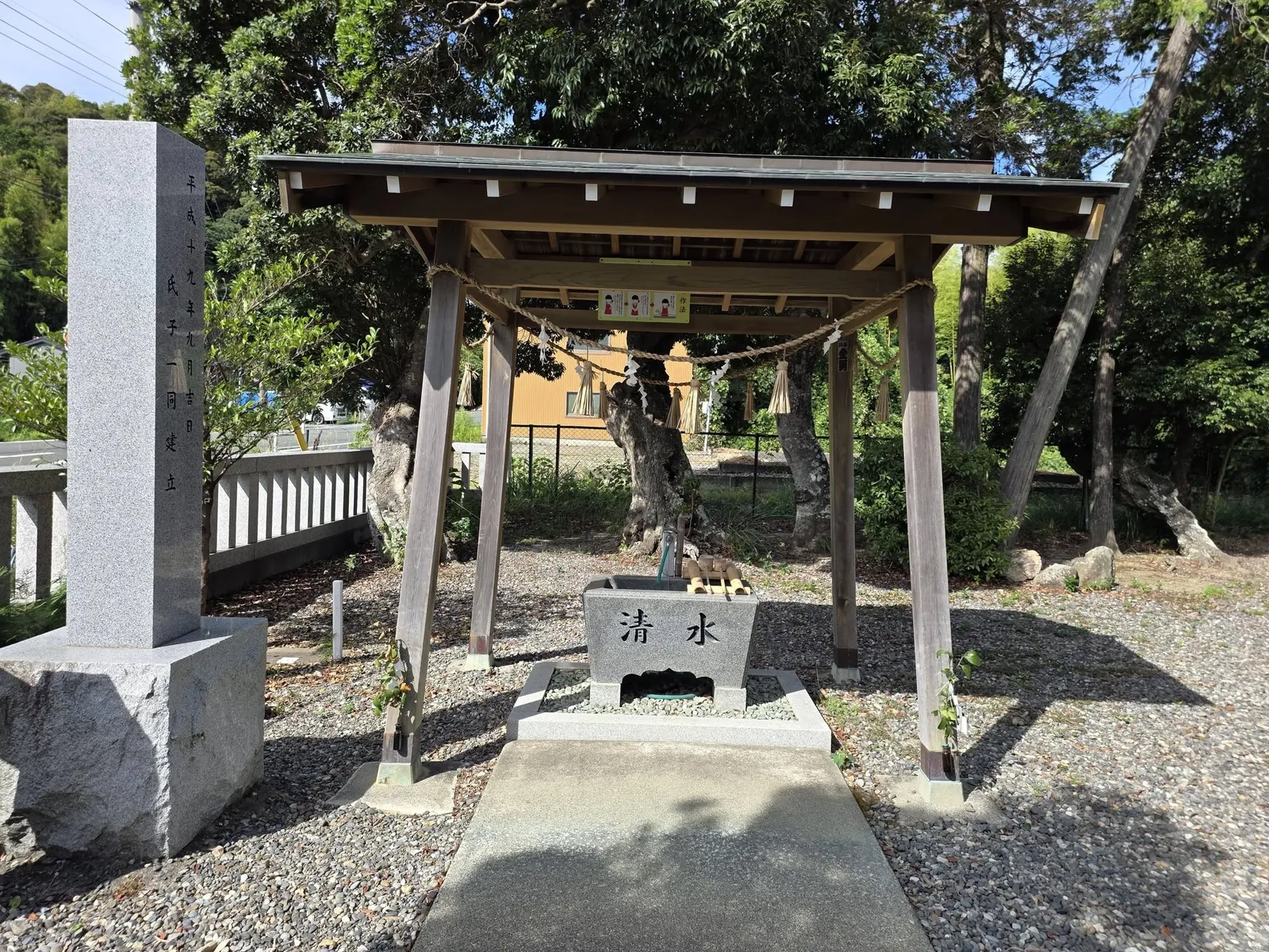 手水舎の全景。「清水」と刻まれた水盤と、氏子一同建立の石柱が並ぶ。