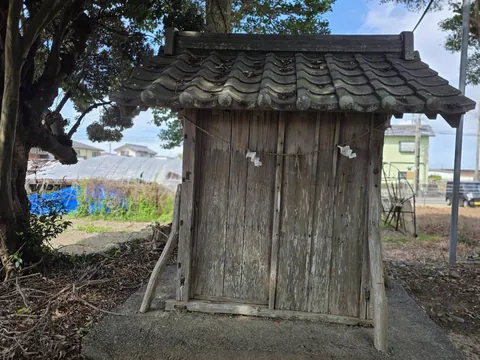 境内社（祠）の正面。瓦葺きの屋根と木製の扉、しめ縄と紙垂が見える。