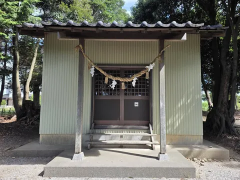 社殿正面。しめ縄と紙垂が渡された扉と、瓦葺きの妻入りの屋根が見える。