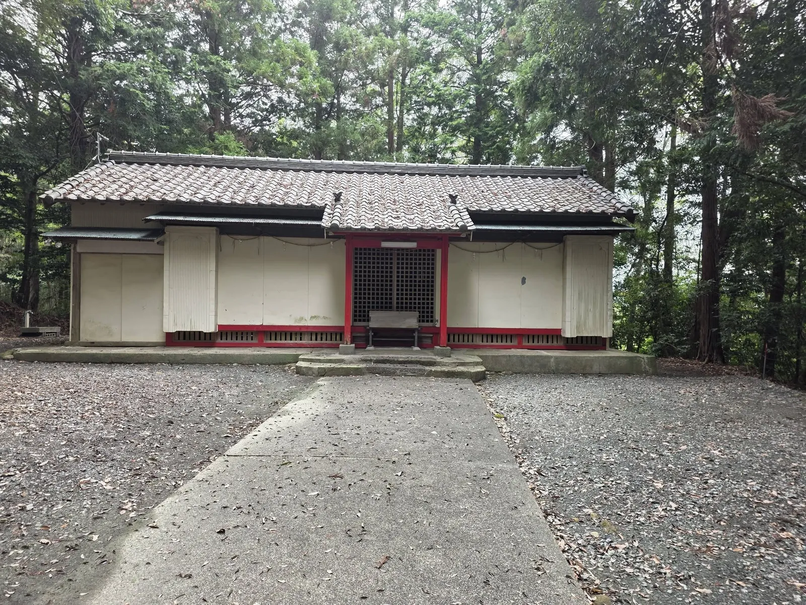 参道正面から見る社殿。白壁と朱塗りの柱を備える。