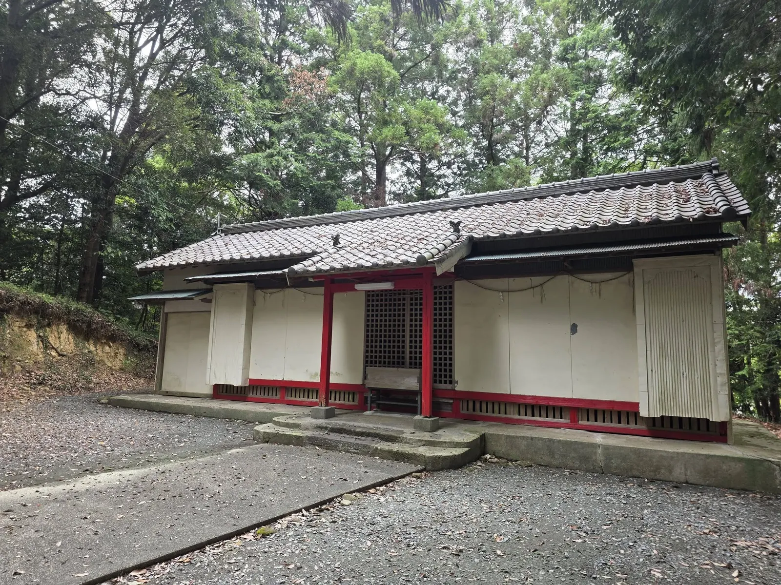 社殿を斜め前から見る。切妻屋根と白壁の外観を記録する。