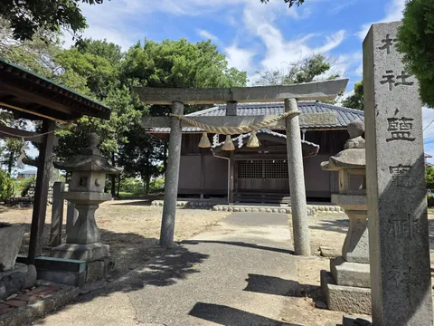 塩竃神社：社号標「村社鹽竈神社」と石造鳥居、両脇の石灯籠。奥に社殿が見える。