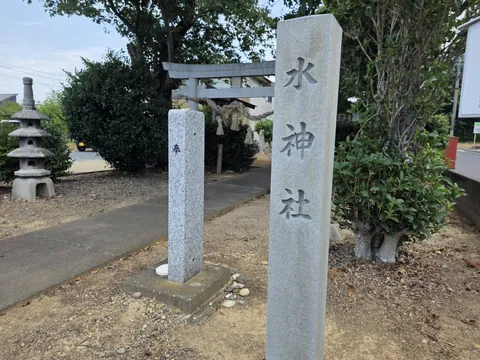 社号標「水神社」と奉献の標柱。奥に石造の鳥居。
