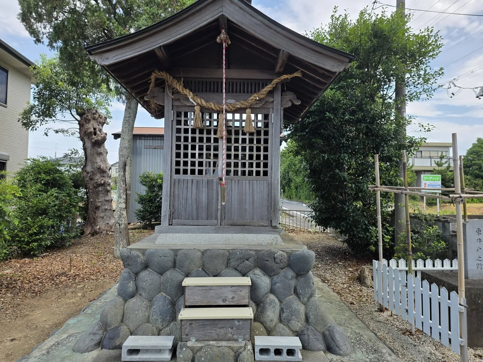 社殿正面。玉石積みの基壇上に建ち、鈴縄を下げる。