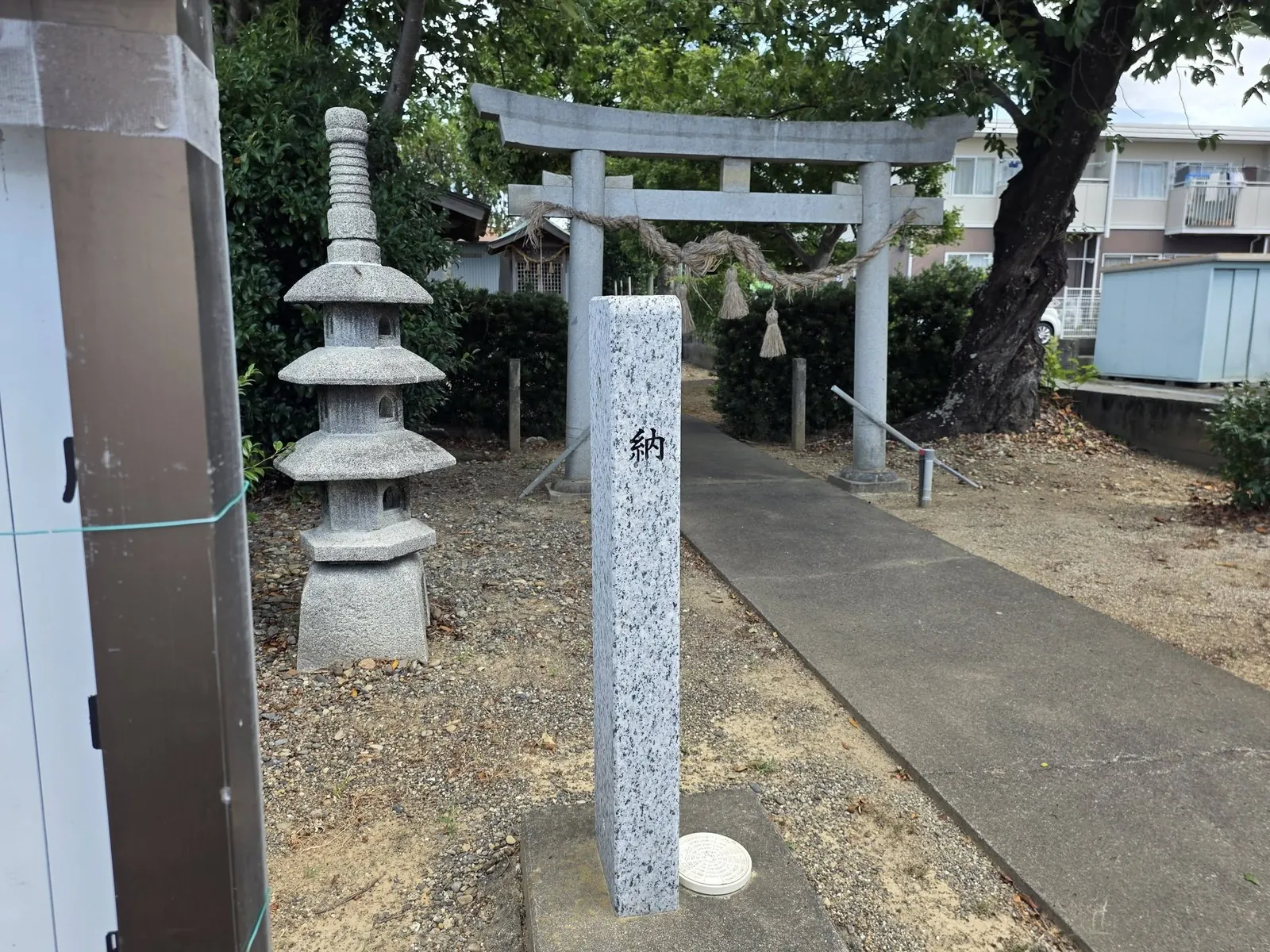 境内入口の石灯籠と「納」の標柱。奥は鳥居。