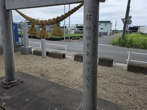 注連縄を掛けた石造鳥居と柱の奉納銘。