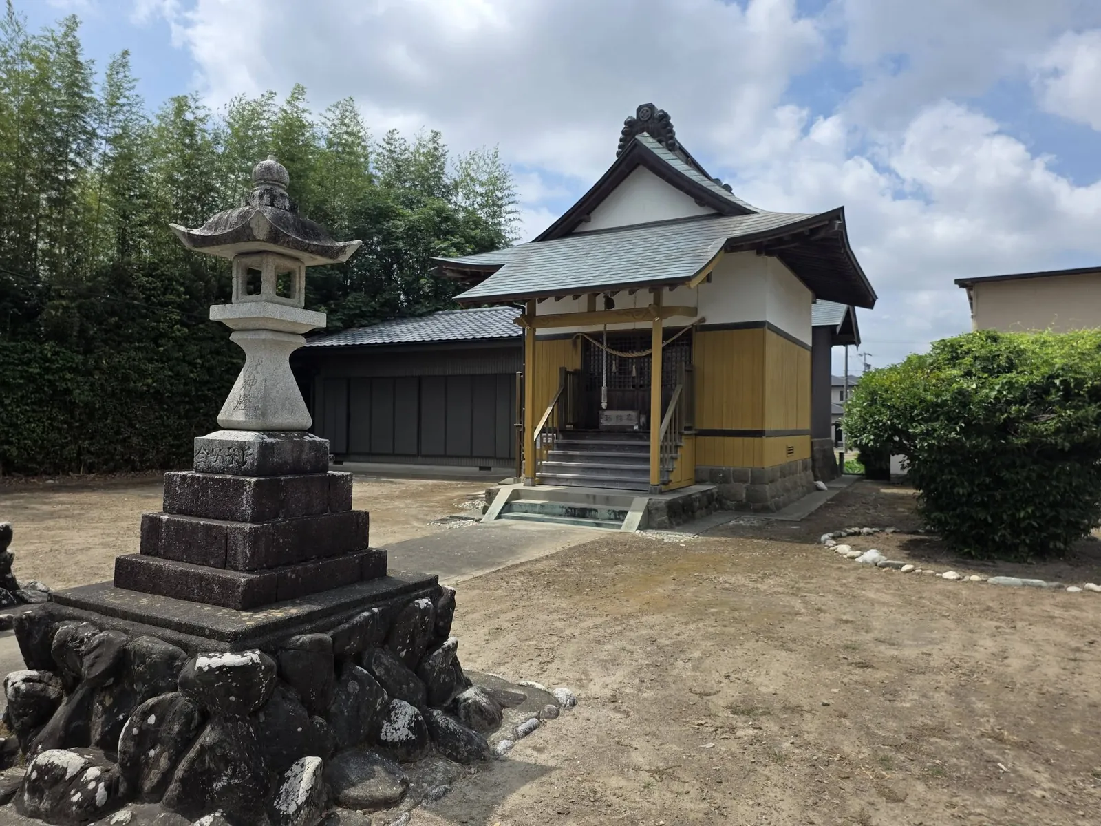 石灯籠を前に建つ諏訪神社の社殿。