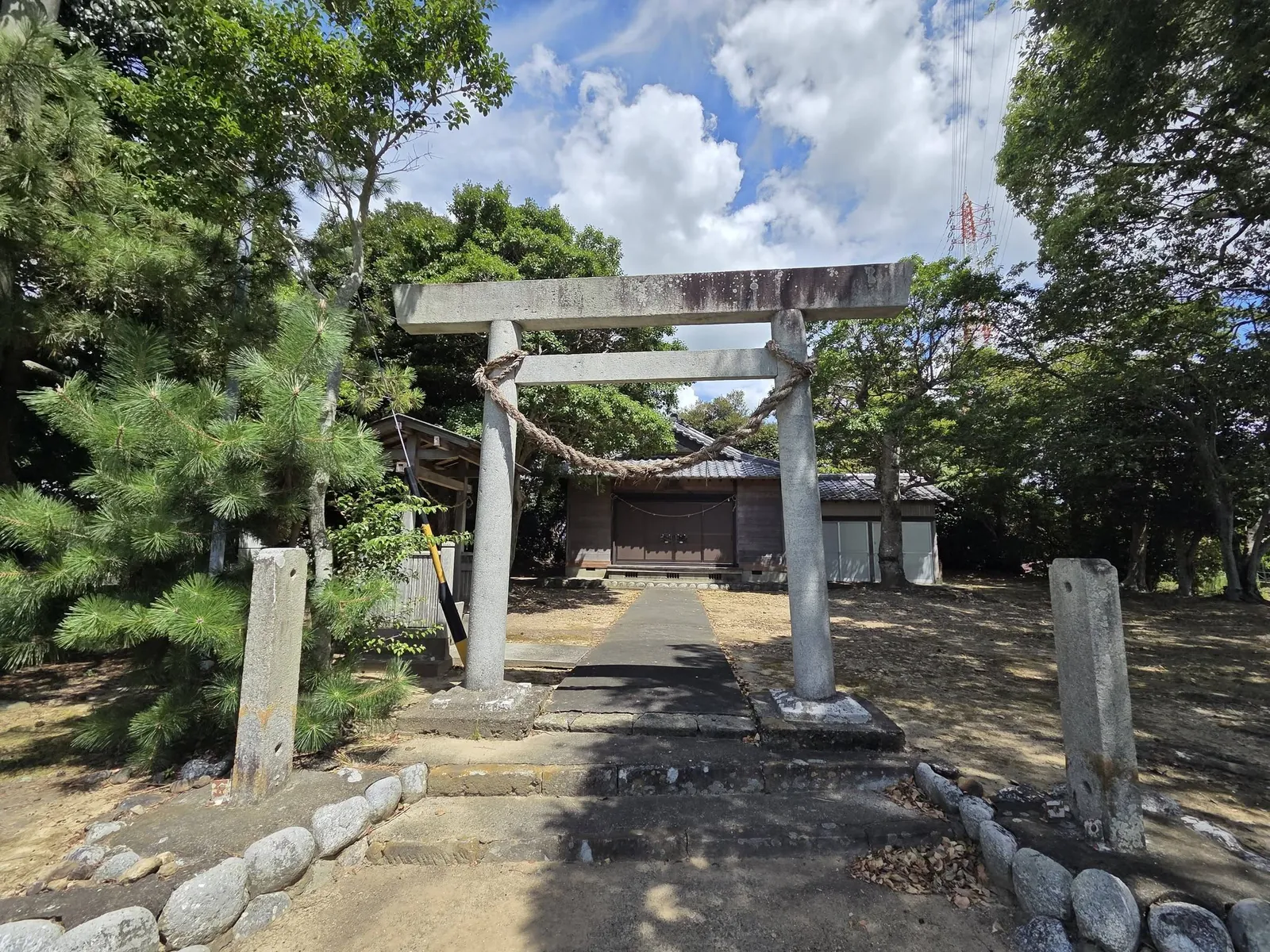 鳥居正面から見た境内。注連縄の奥に社殿と手水舎が見える。