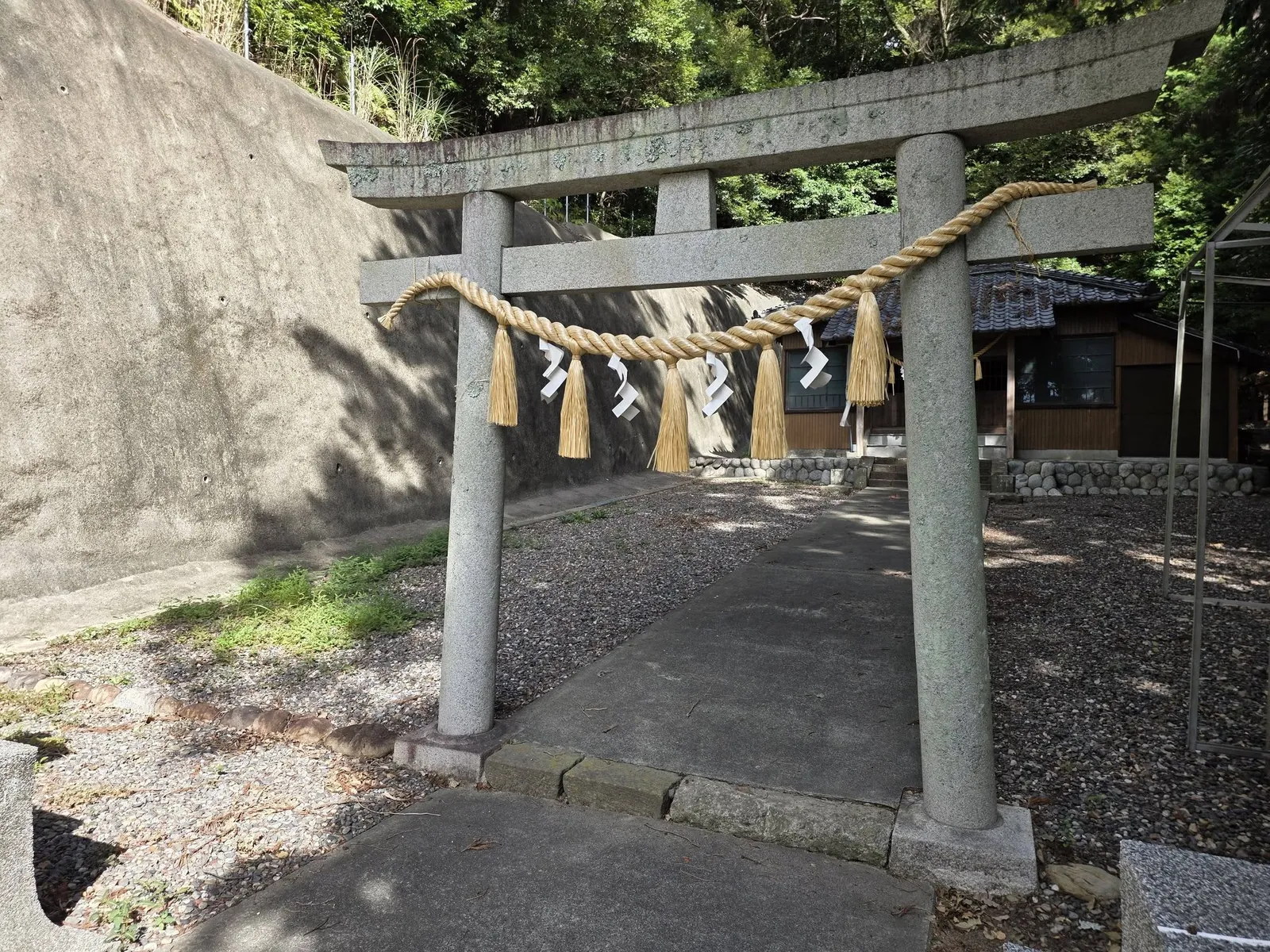 鳥居正面。注連縄の奥に社殿と隣接する建物が見える。