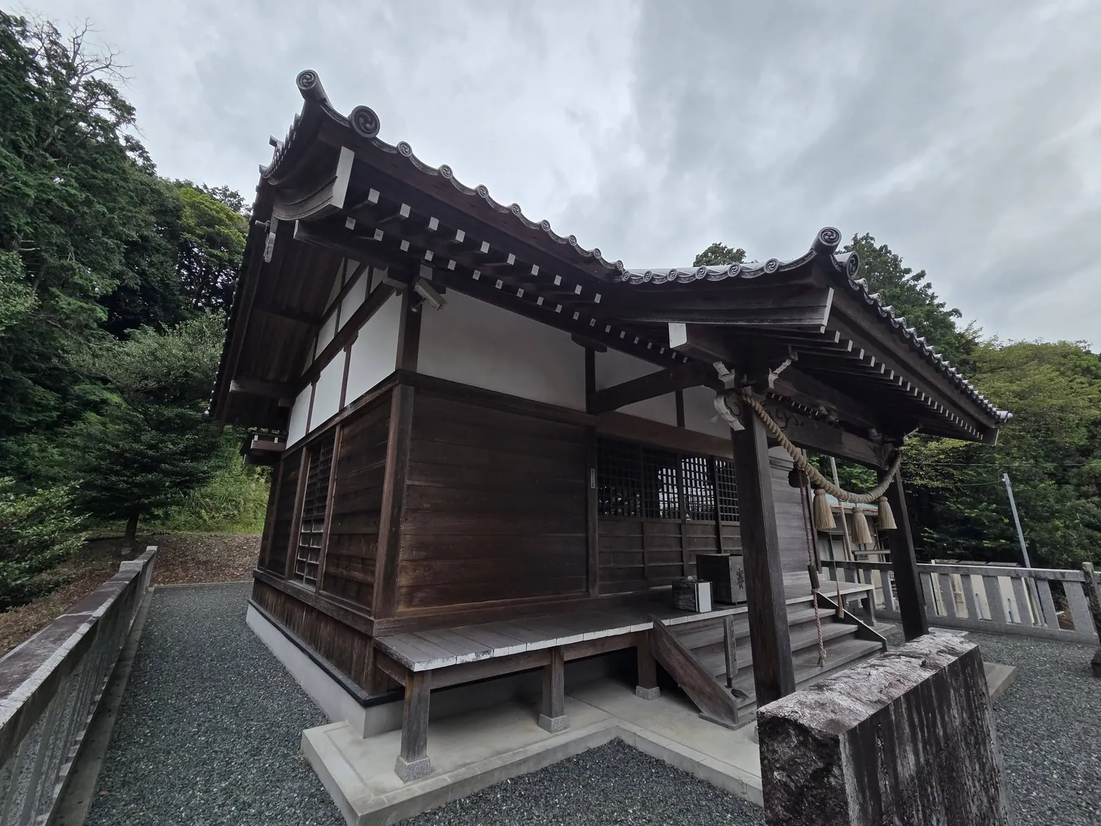 社殿側面。瓦葺の屋根と向拝の木組みを記録する。