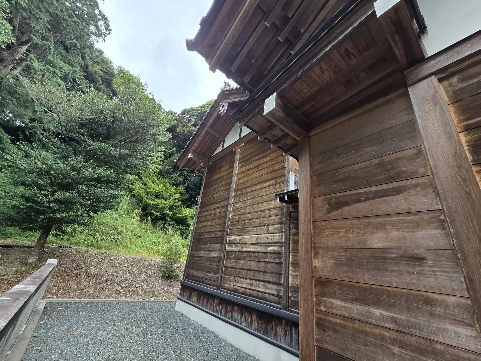 社殿背面側の外観。木造の壁面と高欄を記録する。