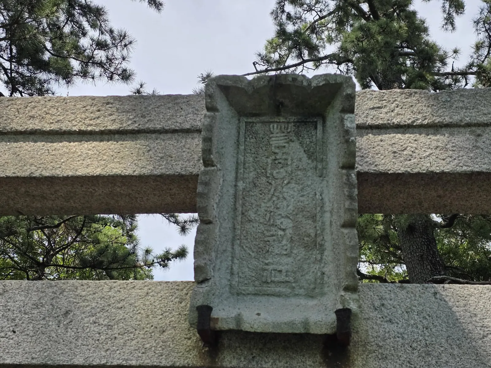 石造鳥居の額束に刻まれた「奉納」の文字。