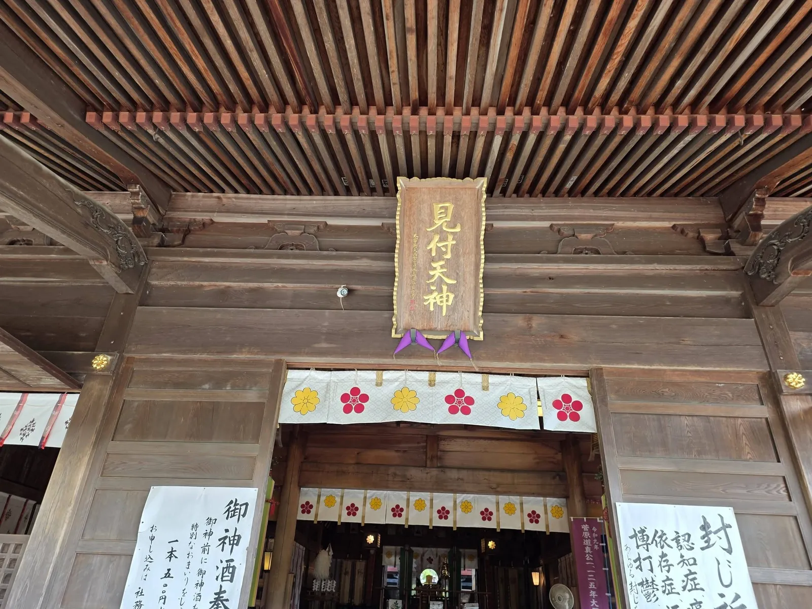 拝殿の正面上部。扁額の下に梅鉢紋と菊紋を染めた幕を掛ける。