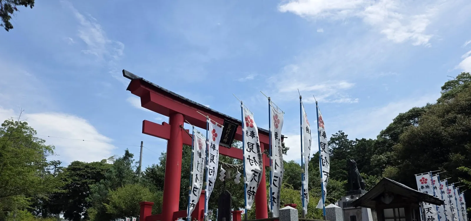 朱塗りの鳥居と「見付天神」の幟旗。右手は霊犬悉平太郎の像。
