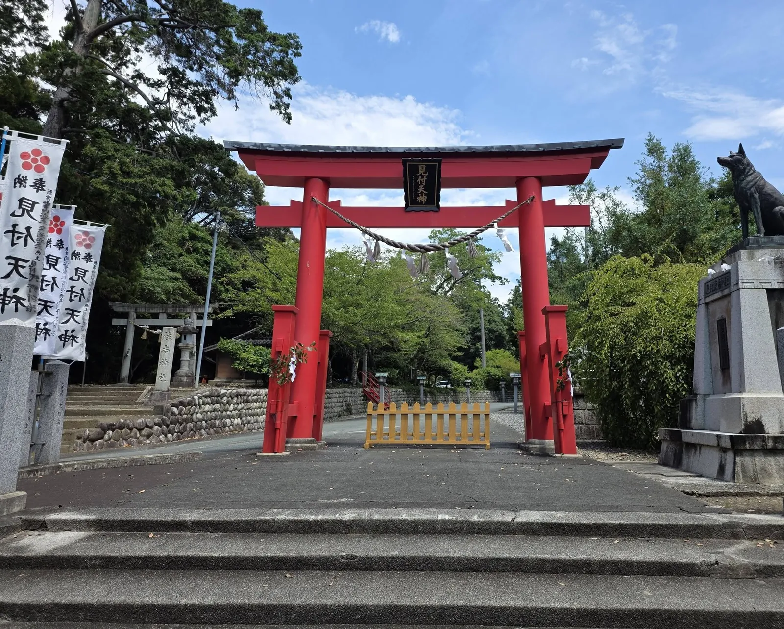 朱塗りの鳥居を正面から見る。扁額は「見付天神」。右は霊犬悉平太郎の像、奥は住吉神社の鳥居。